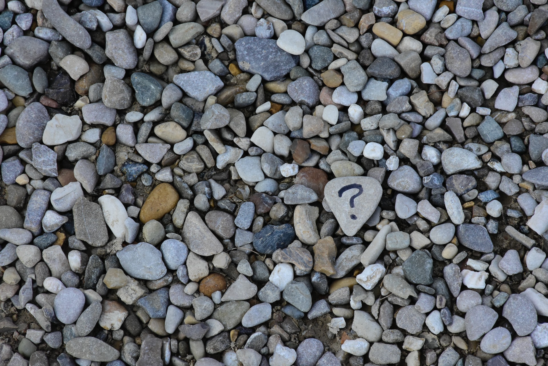 Assortment of pebbles, one with a question mark.